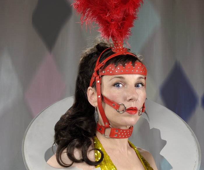 Meret Becker mit einem zirkusartigen Kostüm blickt in die Kamera