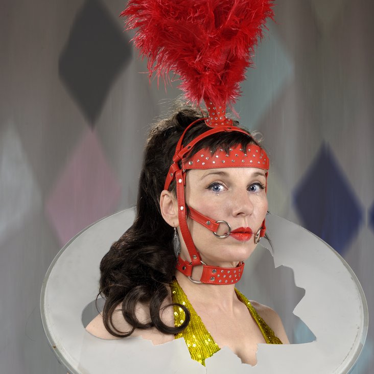 Meret Becker mit einem zirkusartigen Kostüm blickt in die Kamera
