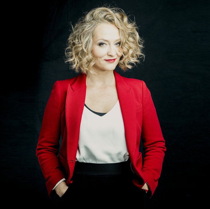 Anne Folger posiert in einem roten Blazer