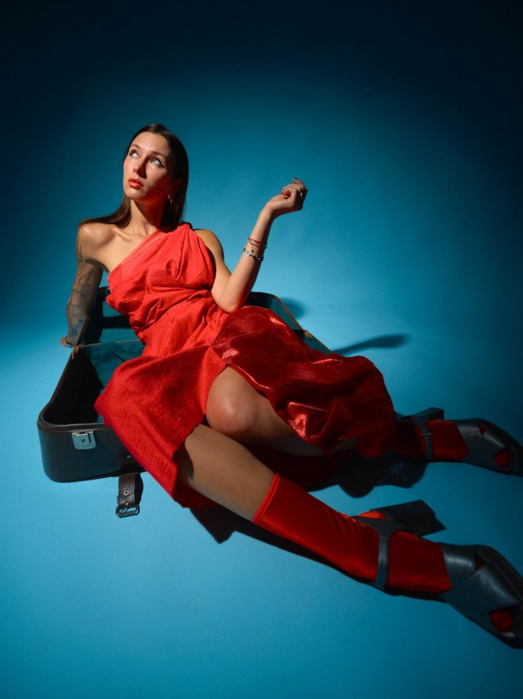 Foto von Gaisma in rotem Kleid vor einem blauen Hintergrund