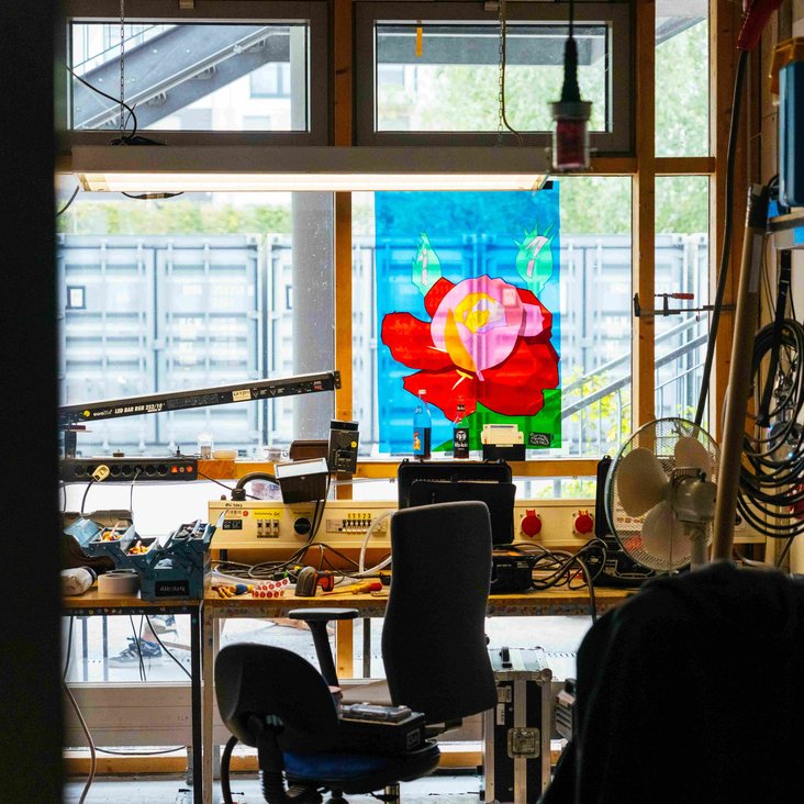 Arbeitsplatz am Fenster mit Schreibtisch, Stuhl und Regal.