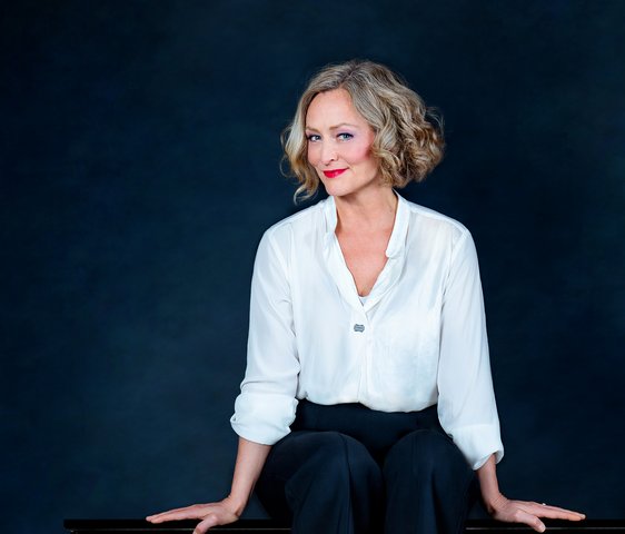 Anne Folger auf einem Klavier sitzend
