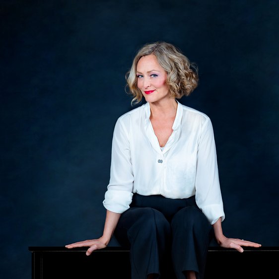 Anne Folger auf einem Klavier sitzend