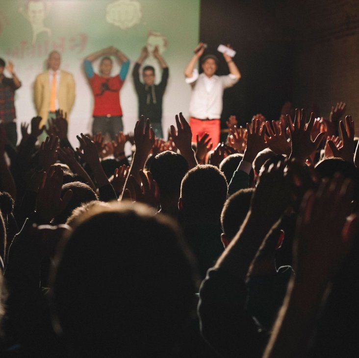 Teilnehmende des Science Slam auf der Bühne vor Publikum