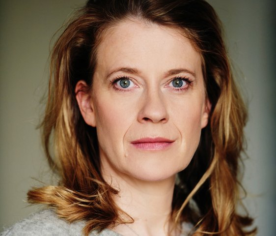 Portraitfoto von Caroline Peters, sie trägt einen grauen Pullover