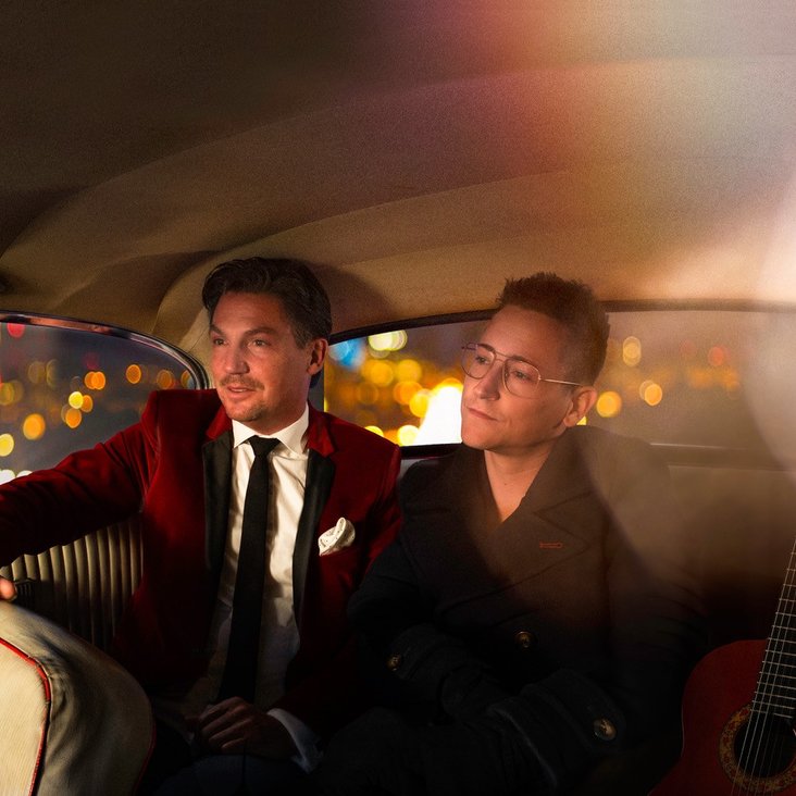 Die beiden Café del Mundo Musiker sitzen auf der Rückbank eines Autos und blicken aus dem Fenster