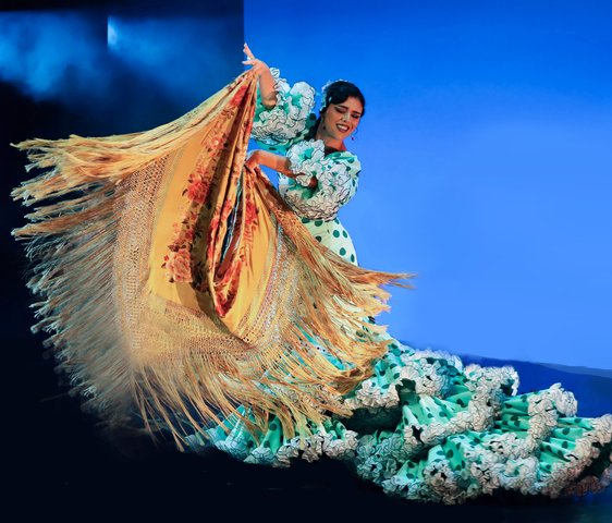 Tänzerin in aufwändig gestaltetem Flamenco Kleid auf der Bühne