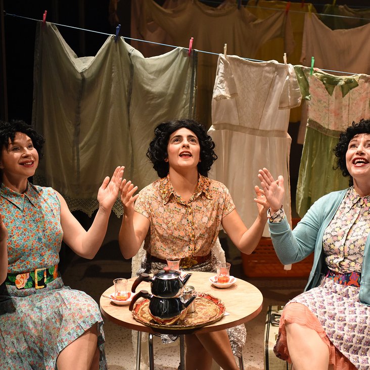 Drei Frauen sitzen an einem Tisch und singen gemeinsam