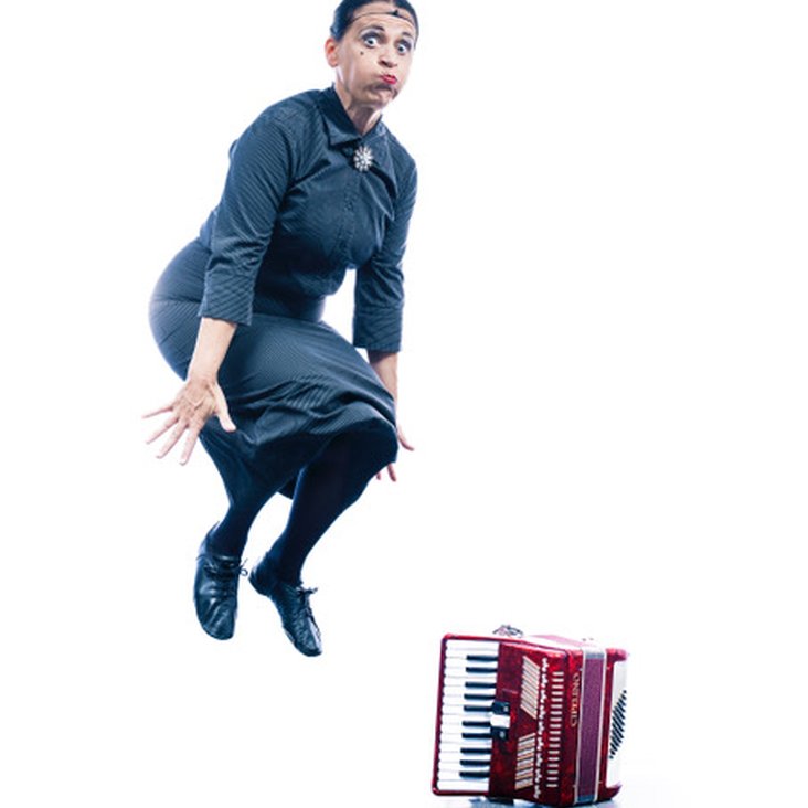 Carmela de Feo springt in die Luft, neben ihr steht ein rotes Akkordeon auf dem Boden