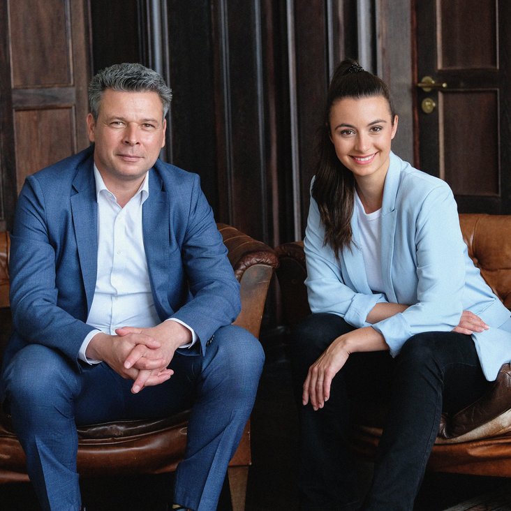 Solveig Gode und Kayhan Özgenc sitzen auf einer Couch