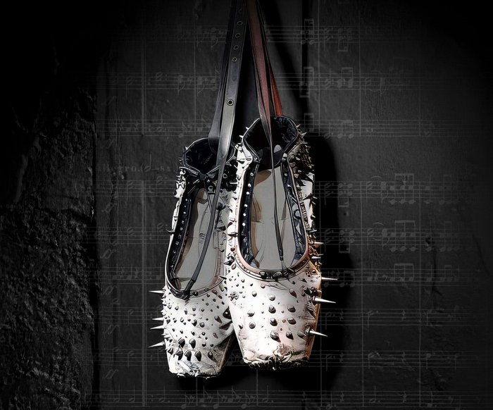 Ein Paar weißer Spitzenschuhe mit Nieten hängt vor einem schwarzen Hintergrund, der mit Musiknoten beschriftet ist.
