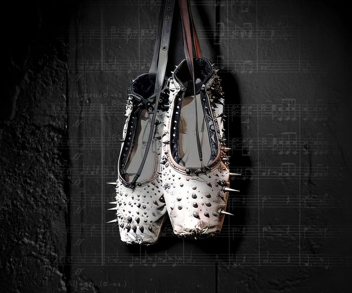 Ein Paar weißer Spitzenschuhe mit Nieten hängt vor einem schwarzen Hintergrund, der mit Musiknoten beschriftet ist.
