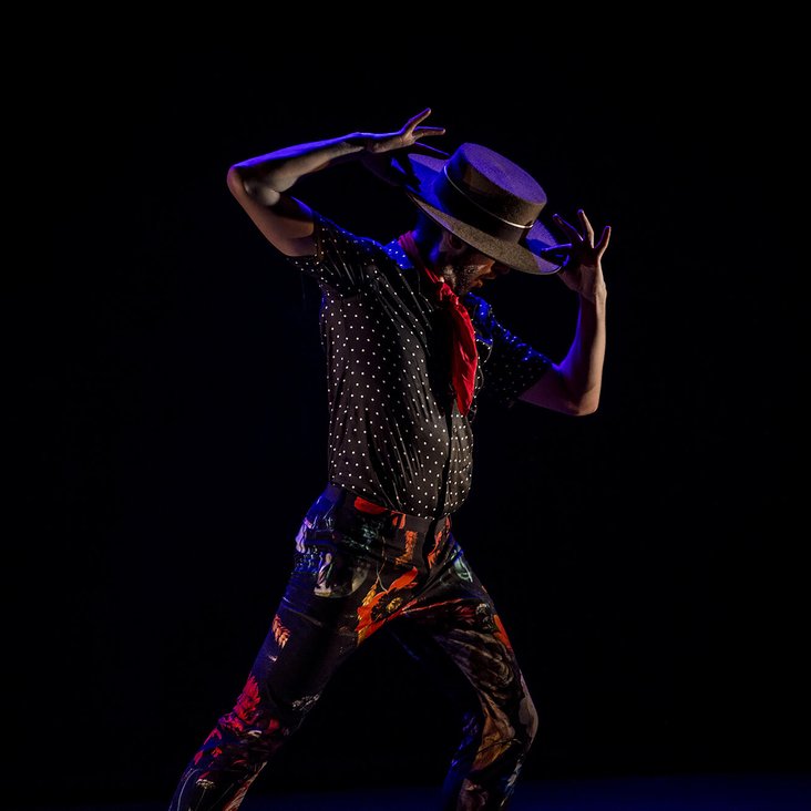Ein Flamencotänzer auf der Bühne greift sich an den Hut
