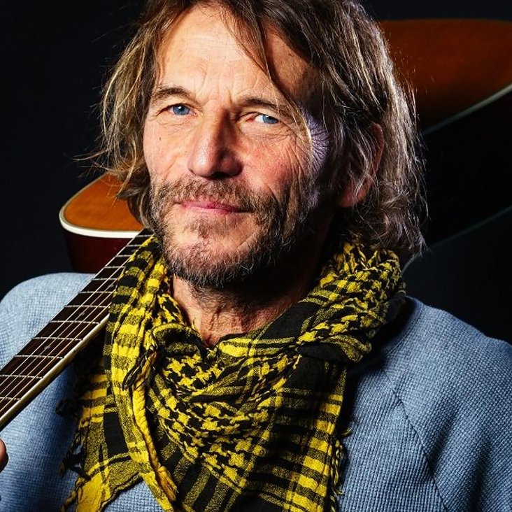 Hans Söllner posiert lässig mit der Gitarre über der Schulter