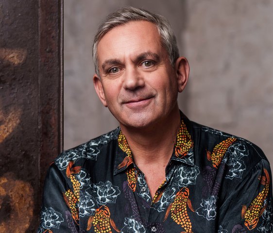 Portraitfoto von Wladimir Kaminer, er trägt ein buntes Hemd.