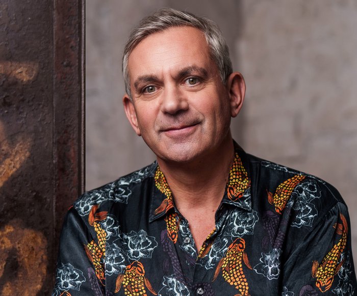 Portraitfoto von Wladimir Kaminer, er trägt ein buntes Hemd.