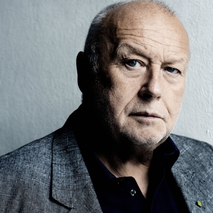 Ein Portrait eines Mann mittleren Alters mit Glatze.
