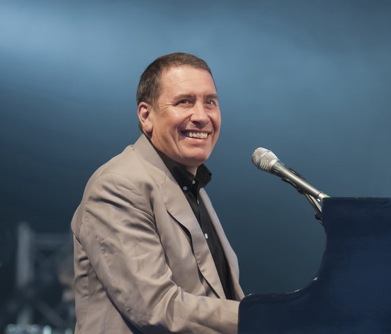 Jools Holland sitzt mit Anzug bekleidet am Klavier