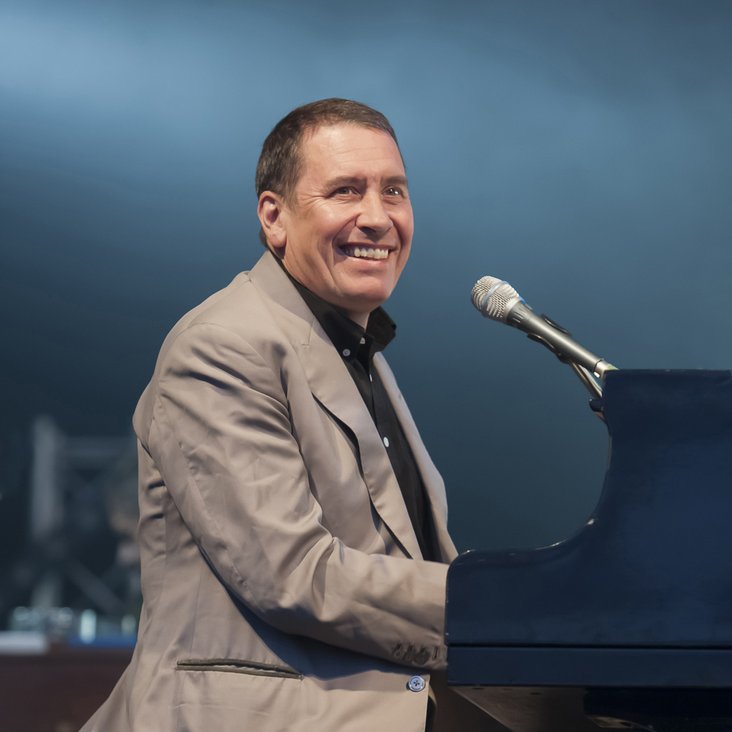 Jools Holland sitzt mit Anzug bekleidet am Klavier