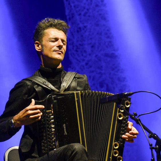 Der Künstler spielt auf seinem Akordion und hat dabei die Augen geschlossen.