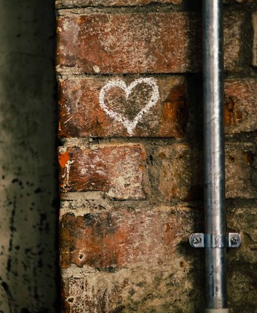 Theaterhaus-typische Wand aus Klinkersteinen mit aufgemalten Kreideherz