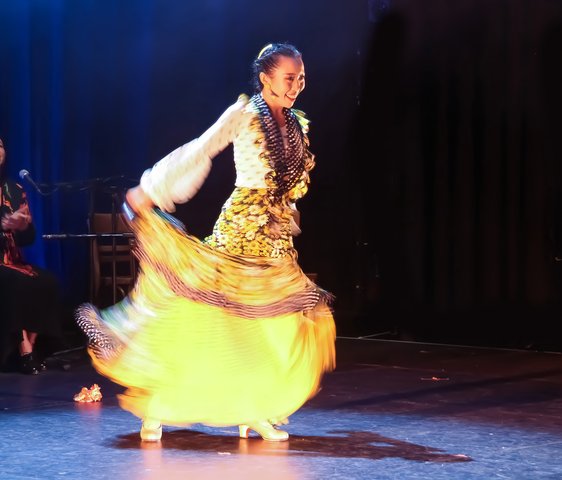 Flamencotänzerin im gelben Kleid auf der Bühne