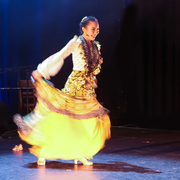 Flamencotänzerin im gelben Kleid auf der Bühne