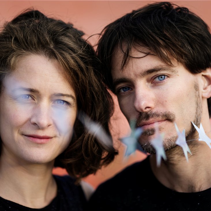 Nahaufnahme der beiden Musiker:innen von Mackefisch mit kleinen Sternen vor ihren Gesichtern.