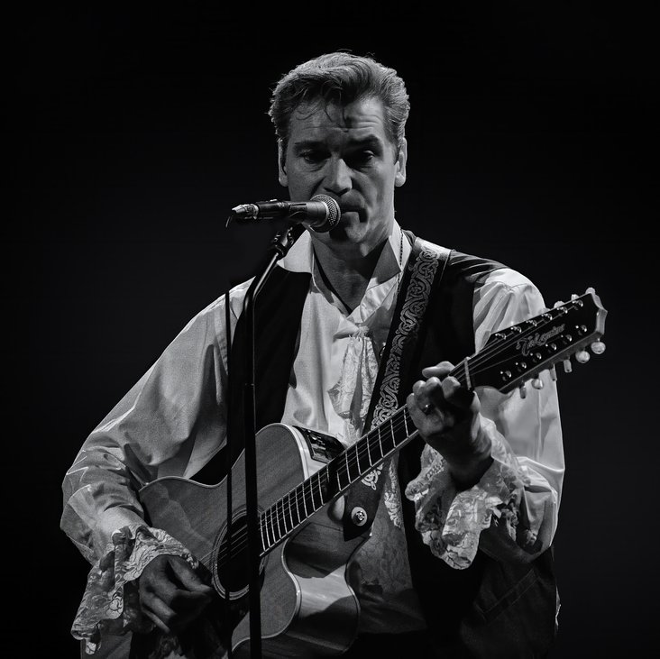 Sänger mit einer Gitarre auf einer Bühne