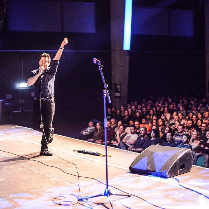 Teilnehmende des Science Slam auf der Bühne vor Publikum