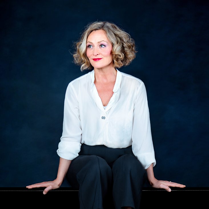 Anne Folger auf einem Klavier sitzend