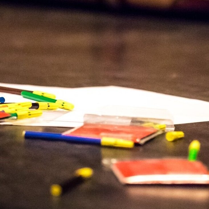 Stifte, Papiere und Notizhefte liegen auf einer Theaterbühne am Boden