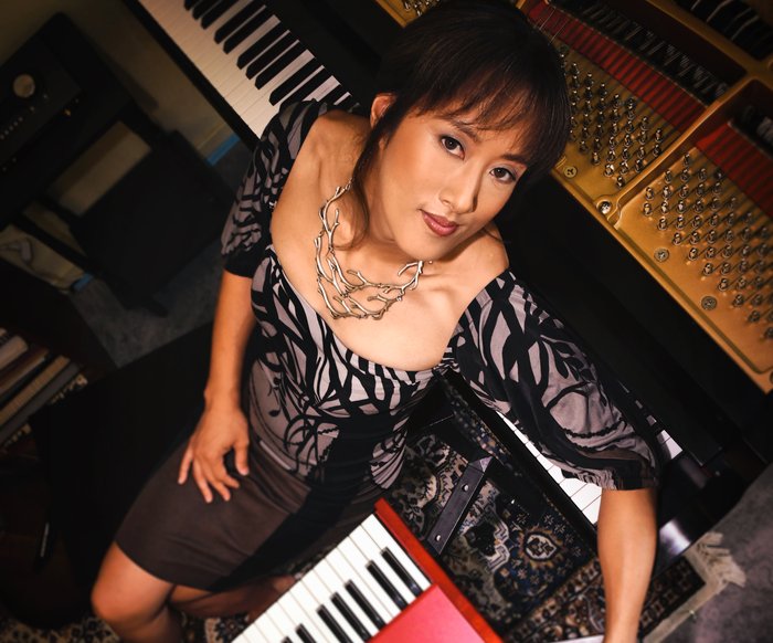 Vienna Teng liegt auf einem Klavier