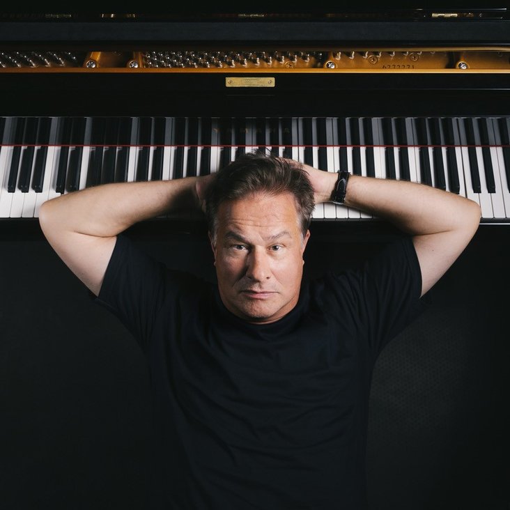 Lars Reichow liegt mit dem Kopf auf einer Klaviatur