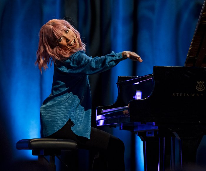 Klara Finck sitzt am Klavier und lacht in die Kamera