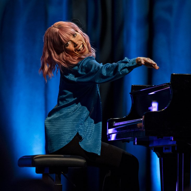 Klara Finck sitzt am Klavier und lacht in die Kamera