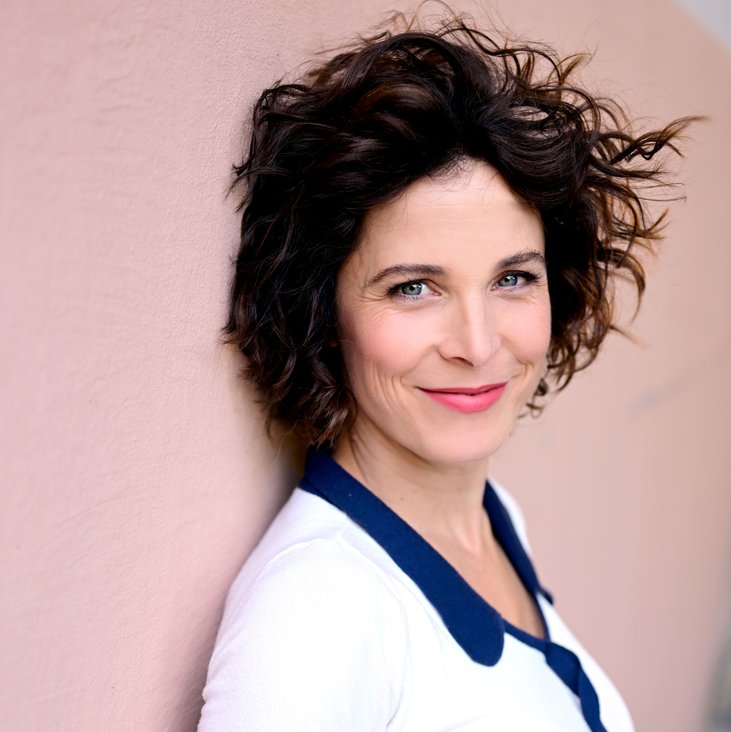 Portraitfoto von Katalyn Hühnerfeld, sie lehnt an einer Wand