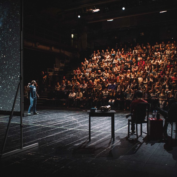 Teilnehmende des Science Slam auf der Bühne vor Publikum