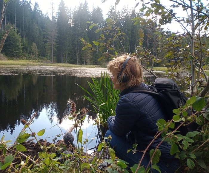 Kirsten Reese am Ufer eines Sees oder Teichs im Wald
