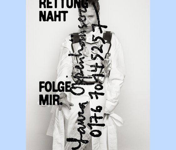 Portraitfoto von Laura Oppenhäuser in weißer Kleidung. Darauf steht handschriftlich mit schwarzem Edding ihr Name und eine Handynummer. Außerdem "Rettung naht" und "Folge mir".