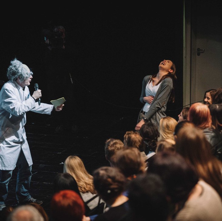 Teilnehmende des Science Slam auf der Bühne vor Publikum
