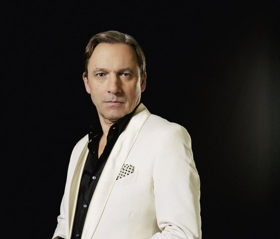 Rocko Schamoni im weißen Anzug und schwarzen Hemd